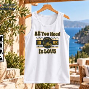 All You Need Is Love Vintage Football Helmet Graphic Shirt 2 All You Need Is Love vintage football shirt graphic with a dark helmet, gold lettering, and wavy lines