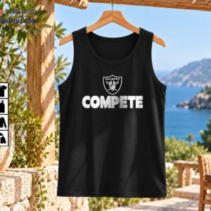 Compete Distressed Football Shield Graphic Shirt 2 Distressed black and white shield emblem with a helmeted figure, crossed swords, RAIDERS text, and bold COMPETE lettering